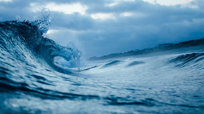 Ocean wave under a cloudy sky